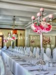 Dekoracja kwiatowa sali weselnej wykonana na wysokich kandelabrach